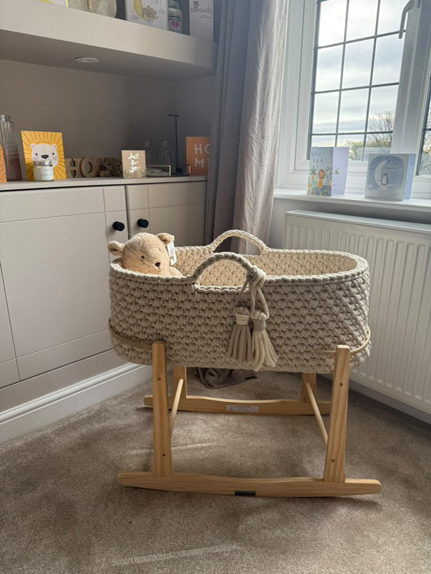 A beige moses basket in a living room so you can see what it might look like in your home