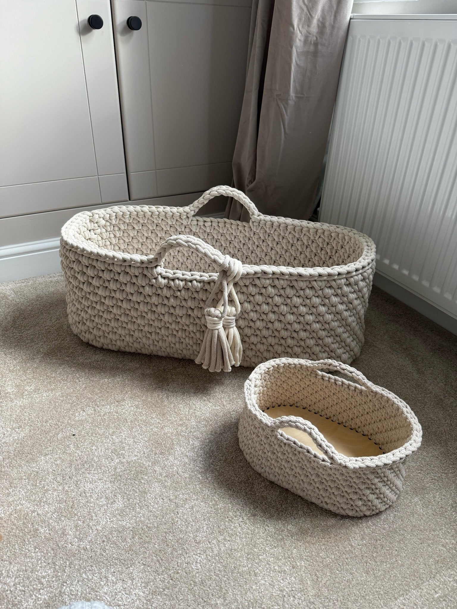 Two crochet baskets on a carpeted floor with a neutral background