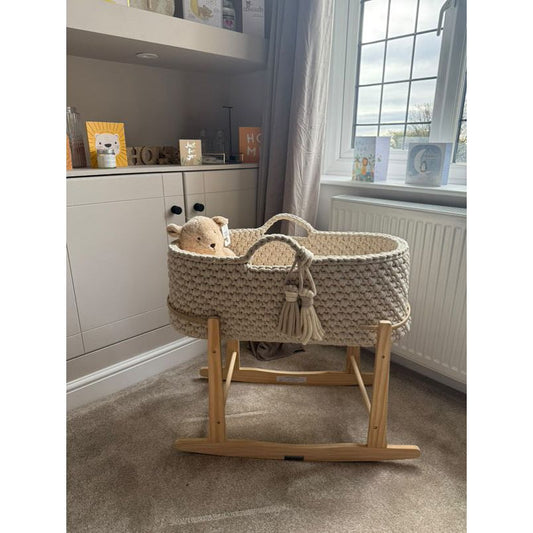A beige moses basket in a living room so you can see what it might look like in your home 