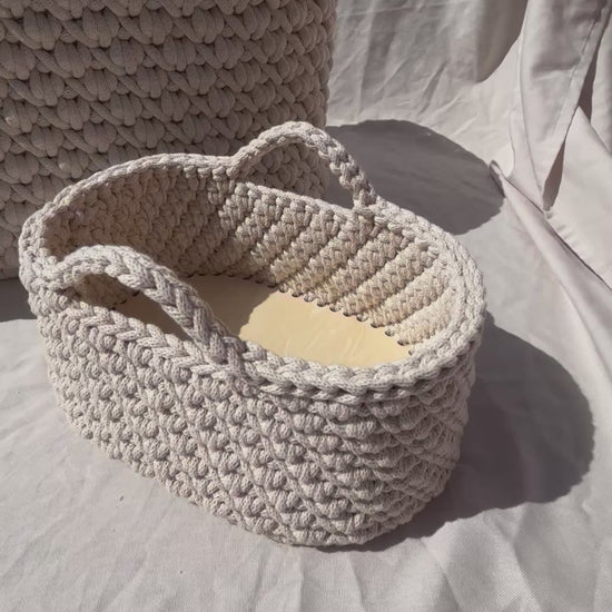 close up video of the moses basket and nappy caddy in the sun on a neutral background